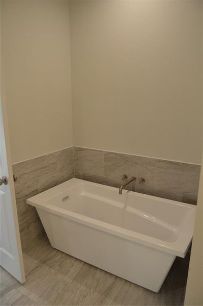 Bathroom featuring a bathtub and tile walls