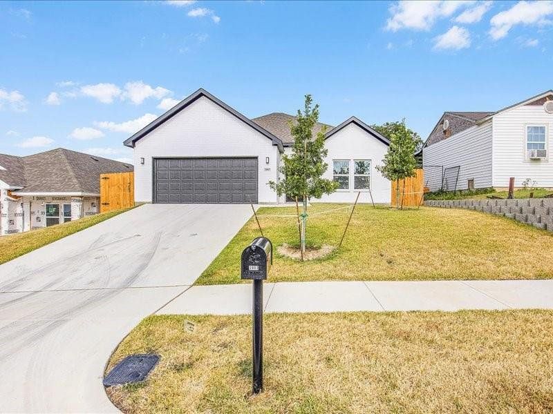 View of front of home with a garage and a front yard