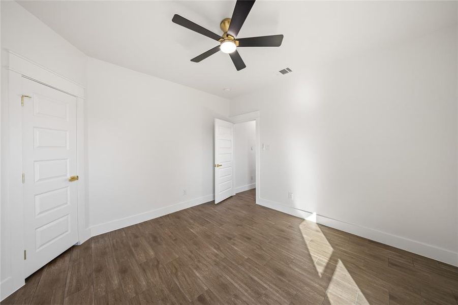 Unfurnished room with dark wood-style flooring and ceiling fan