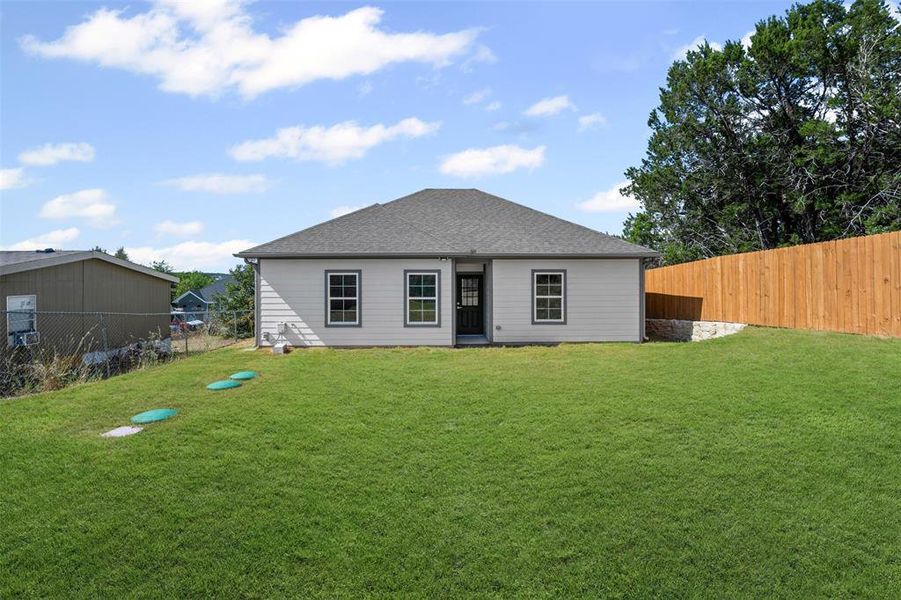 Back of property with a fenced backyard and a shingled roof Back of property with a fenced backyard and a shingled roof