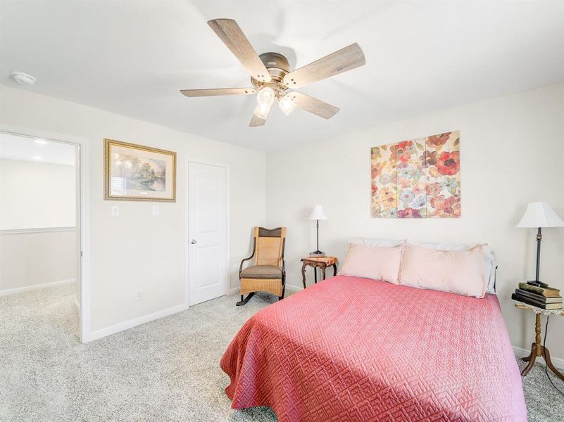Carpeted bedroom with baseboards and ceiling fan