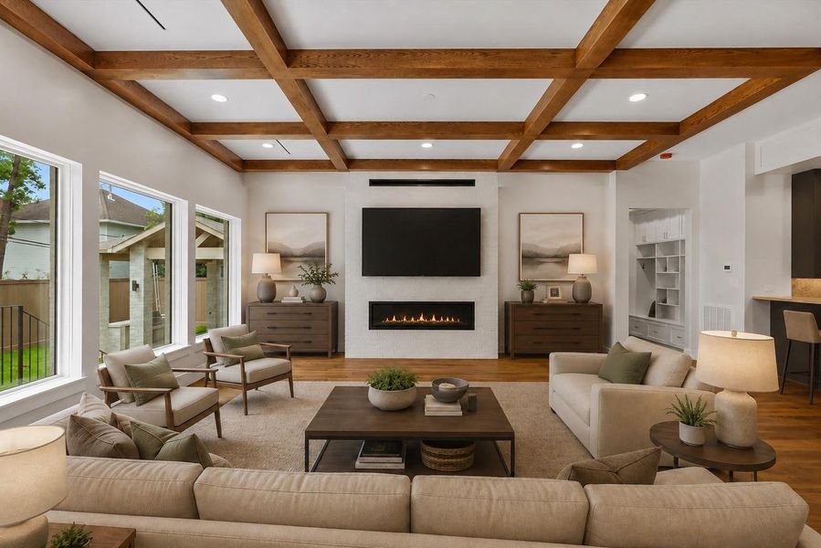 This stunning family room is the heart of the home, showcasing soaring coffered ceilings with rich wood beams, expansive picture windows, and a sleek 60" linear fireplace that anchors the space with warmth and style. Thoughtfully designed for everyday living and effortless entertaining, it offers generous seating, timeless finishes, and an inviting atmosphere that seamlessly blends elegance with comfort.  Virtually staged to illustrate furnishing possibilities.