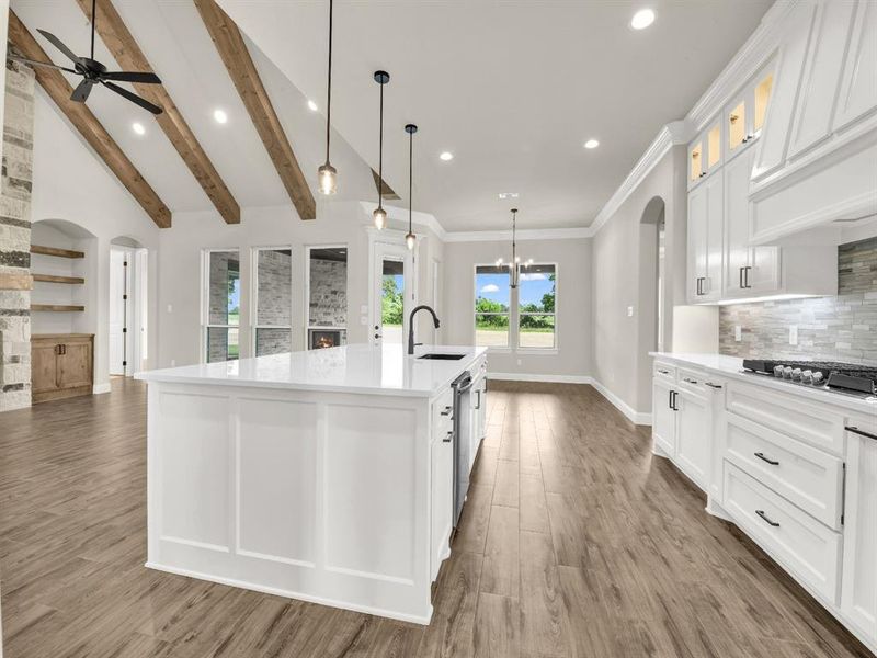 Kitchen with arched walkways, wood finished floors, decorative backsplash, ceiling fan, and recessed lighting Kitchen with arched walkways, wood finished floors, decorative backsplash, ceiling fan, and recessed lighting