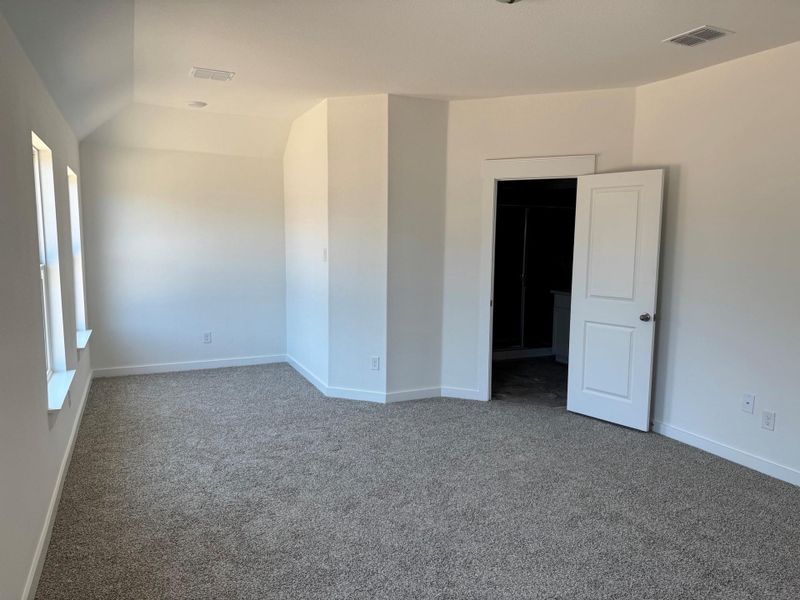 Carpeted spare room featuring vaulted ceiling and healthy amount of natural light Carpeted spare room featuring vaulted ceiling and healthy amount of natural light