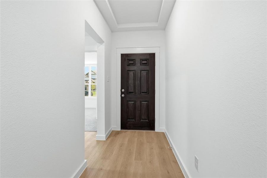 Entryway with wood finished floors and a textured wall