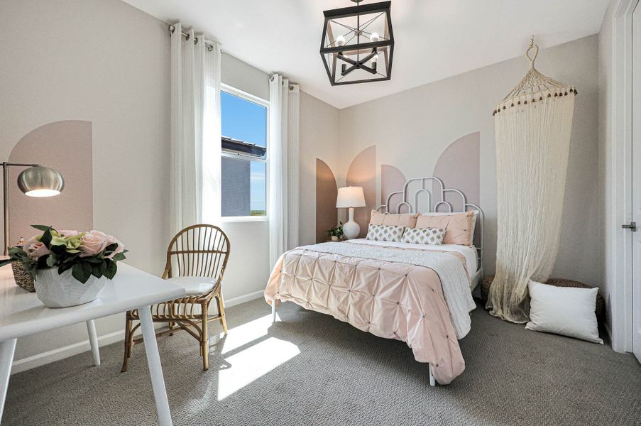 A bedroom with a bed and a table.