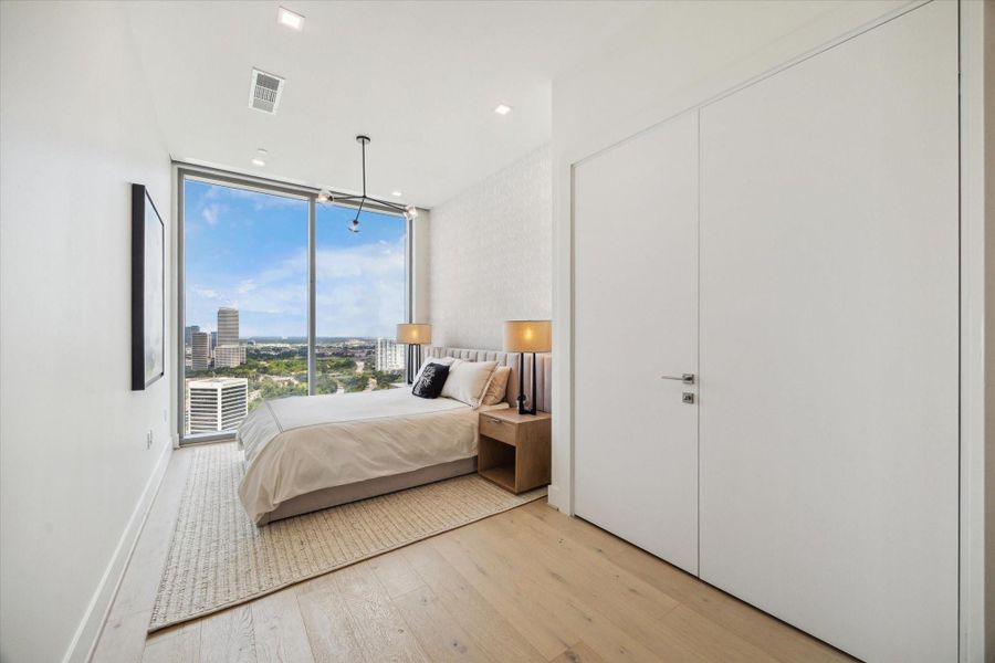 Another view of secondary bedroom that highlights the large closet which is fully built-out by The Container Store with shelving, drawers, and hanging racks.