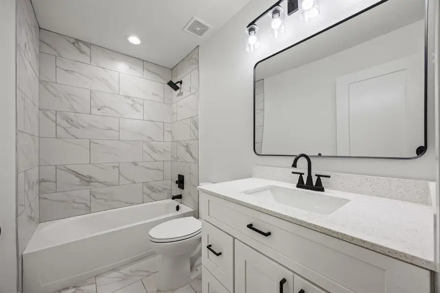 Bathroom with marble finish floors, vanity, shower / tub combination, and recessed lighting Bathroom with marble finish floors, vanity, shower / tub combination, and recessed lighting