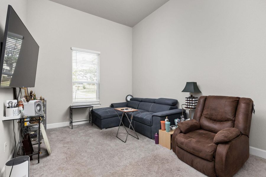Bedroom with light colored carpet and baseboards