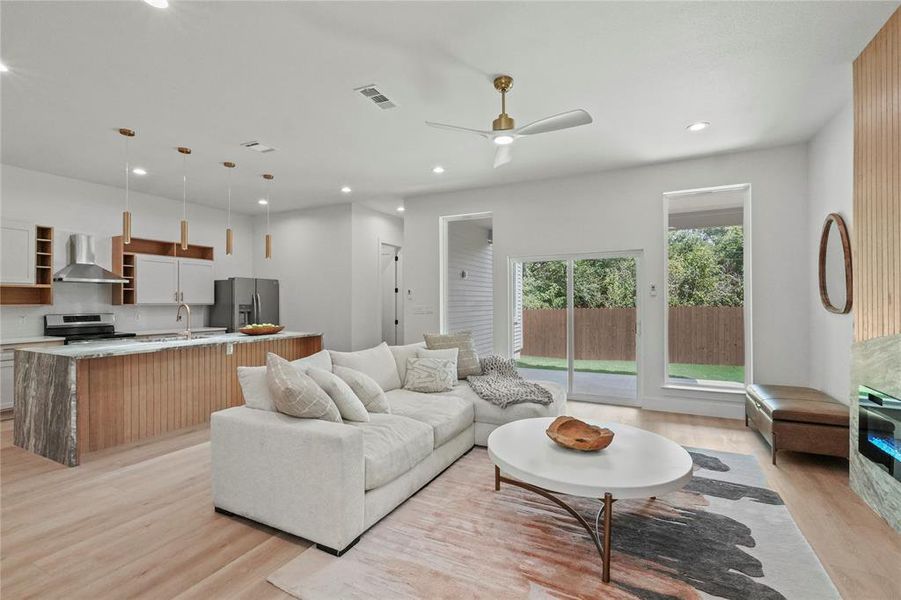 Living room with sink, light hardwood / wood-style floors, and ceiling fan