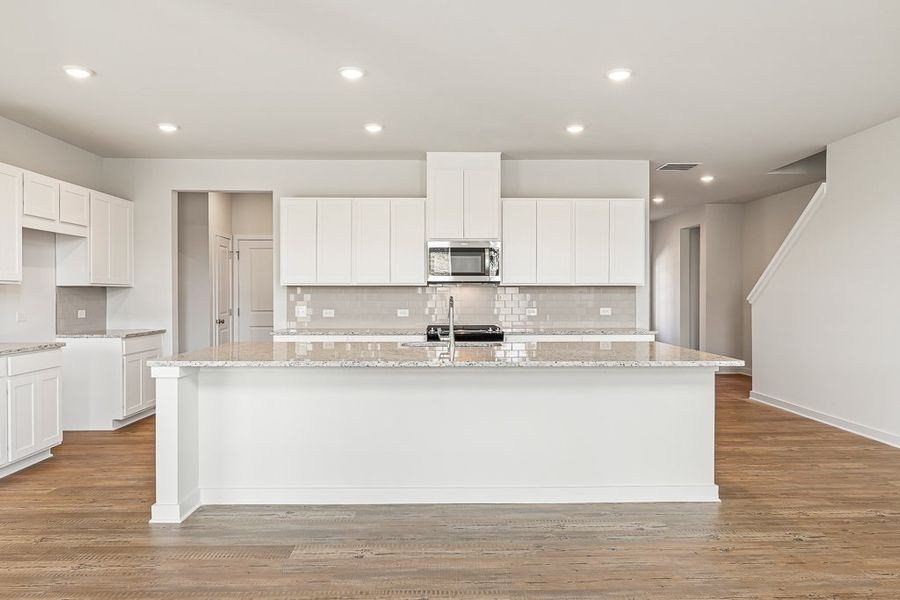 A kitchen with white cabinets.