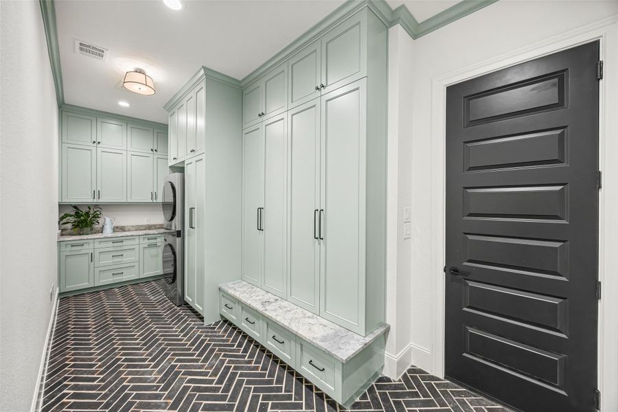 Downstairs laundry room with generous custom cabinetry and elegant designer finishes throughout. Downstairs laundry room with generous custom cabinetry and elegant designer finishes throughout.