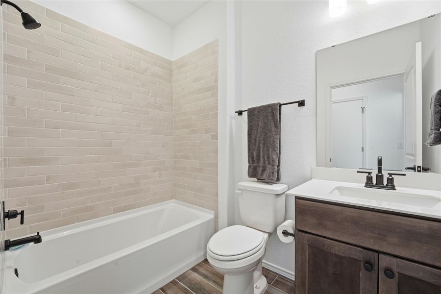 Bathroom with vanity, wood finish floors, and bathtub / shower combination