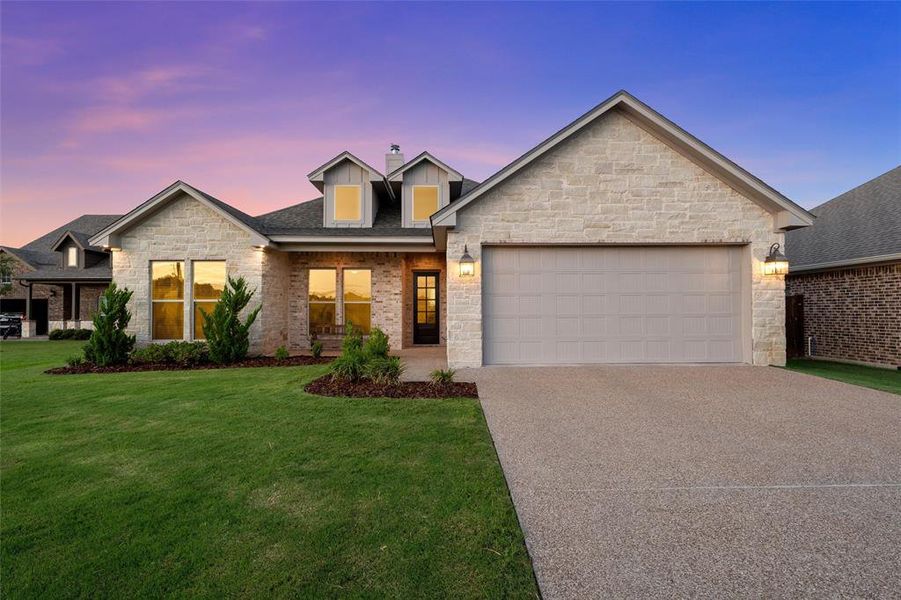 Stone and brick front elevation with covered porch and two-car garage on a quarter-acre lot. Stone and brick front elevation with covered porch and two-car garage on a quarter-acre lot.
