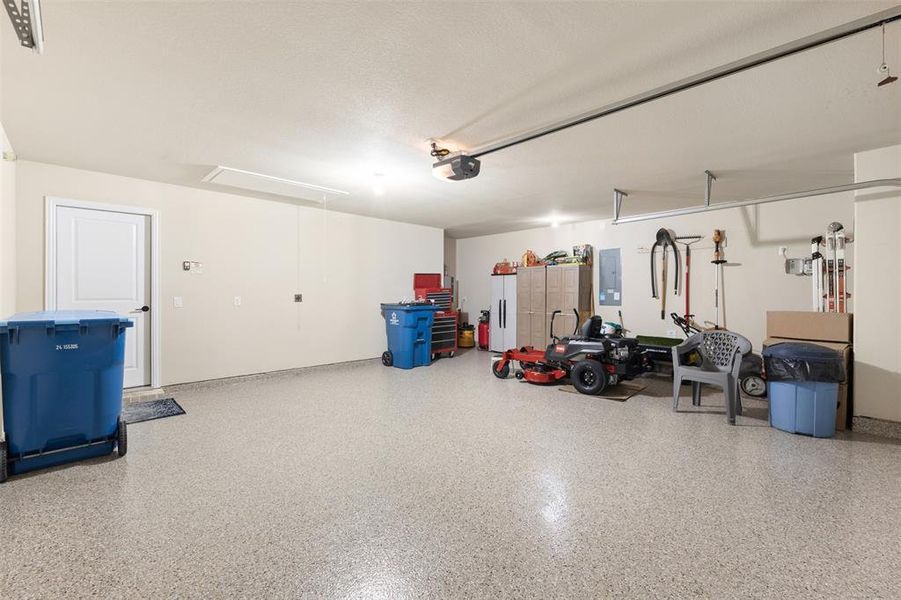 Spacious garage featuring epoxy flooring, painted walls, and built-in shelving Spacious garage featuring epoxy flooring, painted walls, and built-in shelving