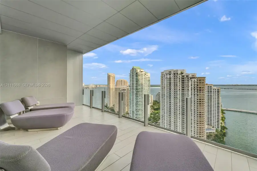 Covered balcony featuring tile flooring, a smooth ceiling finish, and a transparent glass railing Covered balcony featuring tile flooring, a smooth ceiling finish, and a transparent glass railing