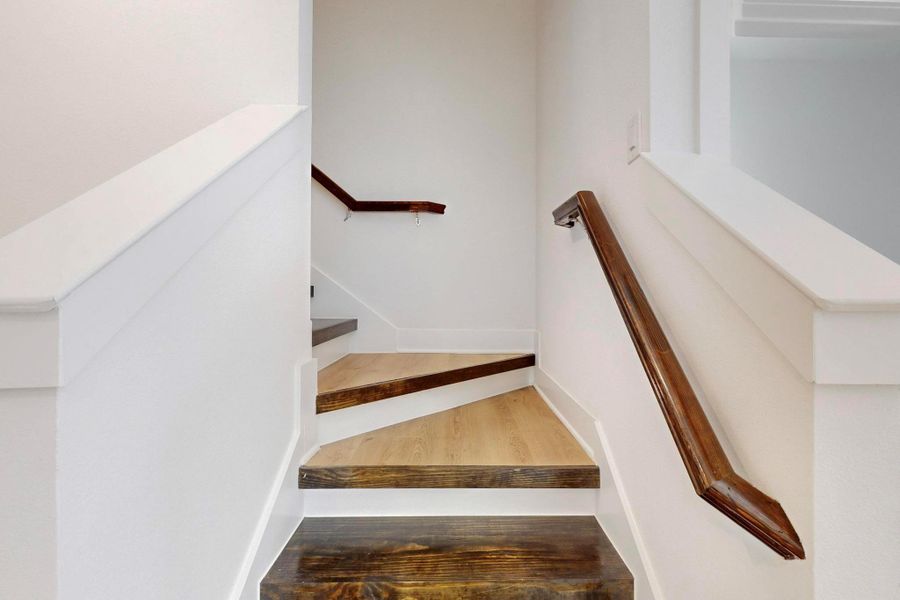 Stairs with wood finished floors and baseboards
