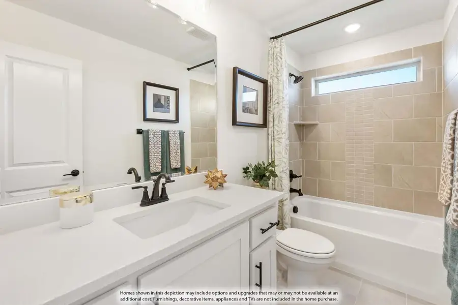 Bathroom with white vanity, quartz countertop, and tiled shower-tub combo with curtain and small window
