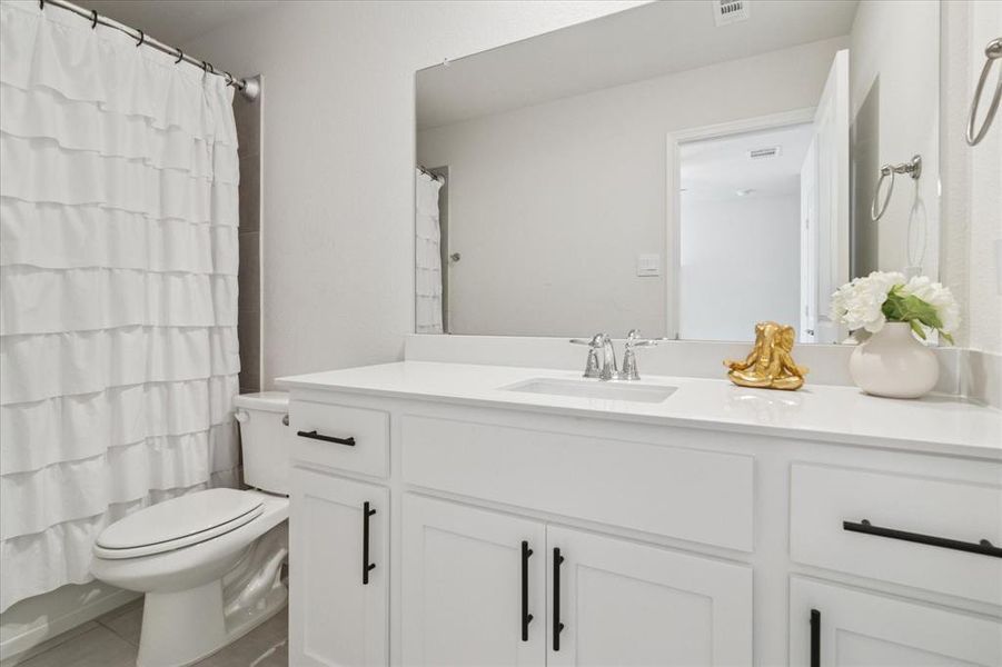 Full bathroom with vanity, tile patterned flooring, and shower / tub combo with curtain Full bathroom with vanity, tile patterned flooring, and shower / tub combo with curtain