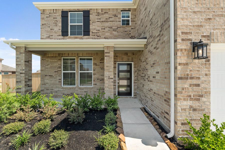 Front exterior of a new home in Sunterra, Katy, TX, highlighting curb appeal (Image 15).