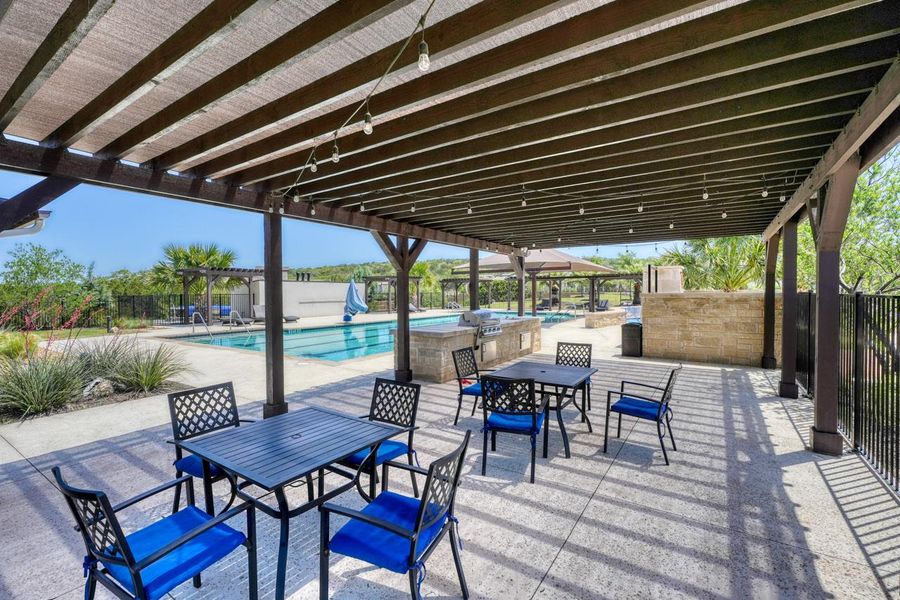 View of patio featuring a pergola, outdoor dining area, a community pool, and grilling area