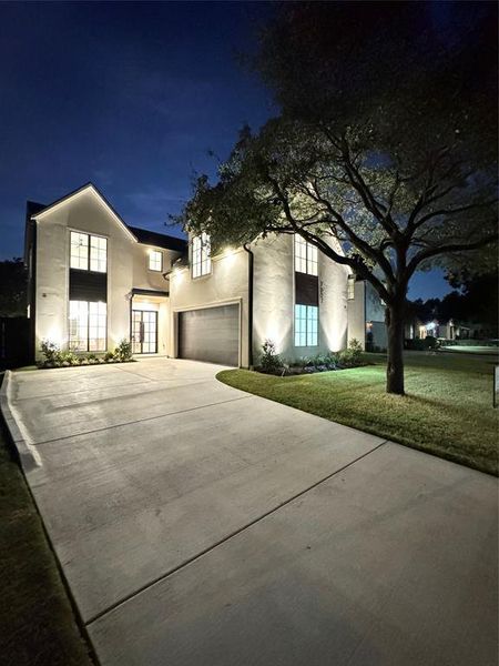 View of front of home featuring a garage and a lawn