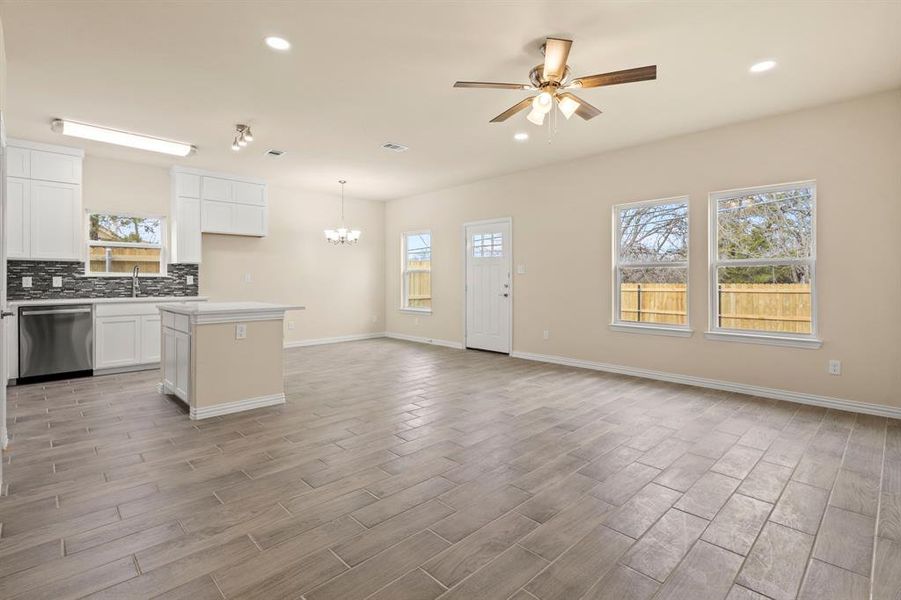 Kitchen with a center island, light wood-style flooring, decorative backsplash, stainless steel dishwasher, and open floor plan