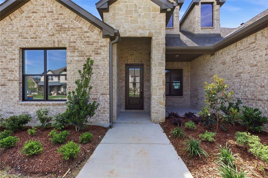 Brick and stone veneer exterior with dark-framed windows