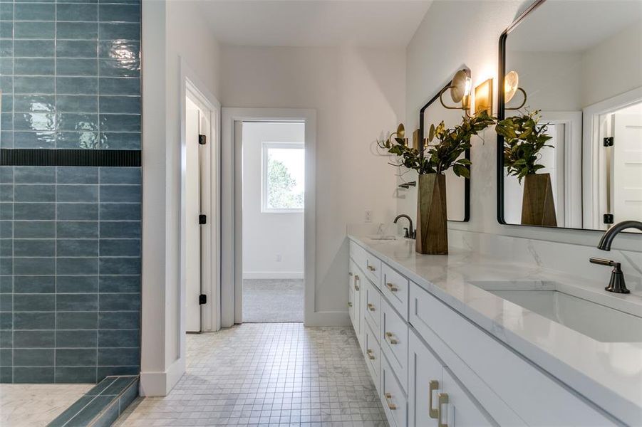 Bathroom featuring vanity with extensive cabinet space, double sink, and tile floors