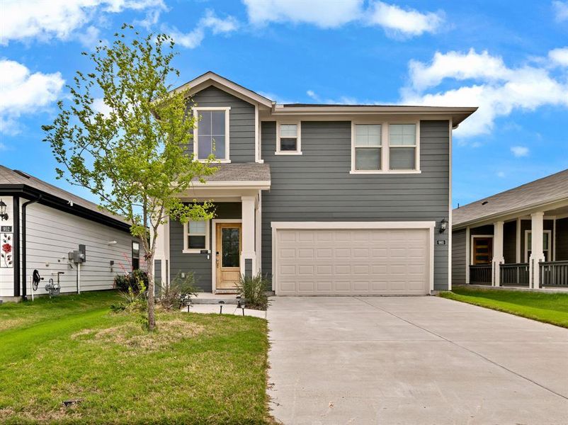 The property features a two-story exterior with dark gray siding, a light wood-toned front door, and a two-car garage