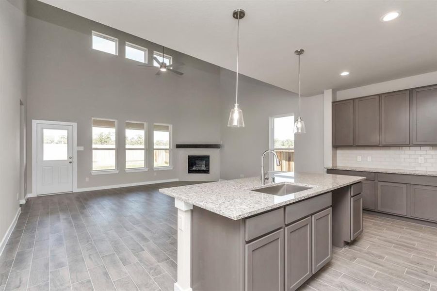 Step into a dream realized with this generously spacious kitchen! A massive granite island takes center stage, complemented by high ceilings, soft-close cabinets, granite countertops, stainless steel appliances, a sleek tile backsplash, and recessed lighting. The extended counter area adds practicality to the stylish design. The open concept effortlessly connects the kitchen to the expansive family room, forming a perfect hub for gatherings. Sample photo of completed home with similar floor plan. As-built i