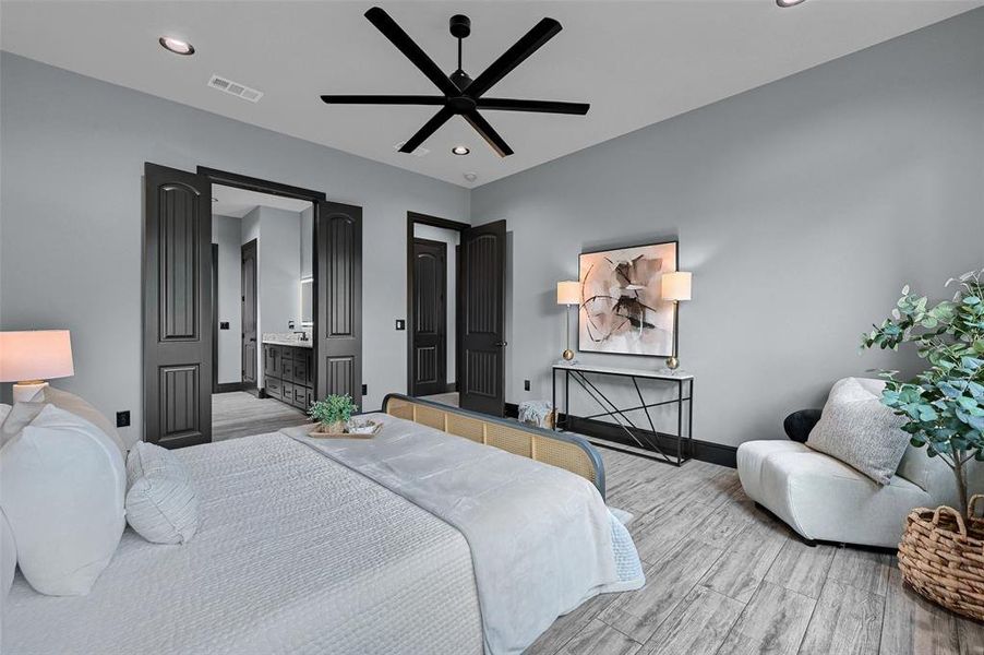 Bedroom featuring light wood finished floors, baseboards, recessed lighting, a ceiling fan, and ensuite bath Bedroom featuring light wood finished floors, baseboards, recessed lighting, a ceiling fan, and ensuite bath