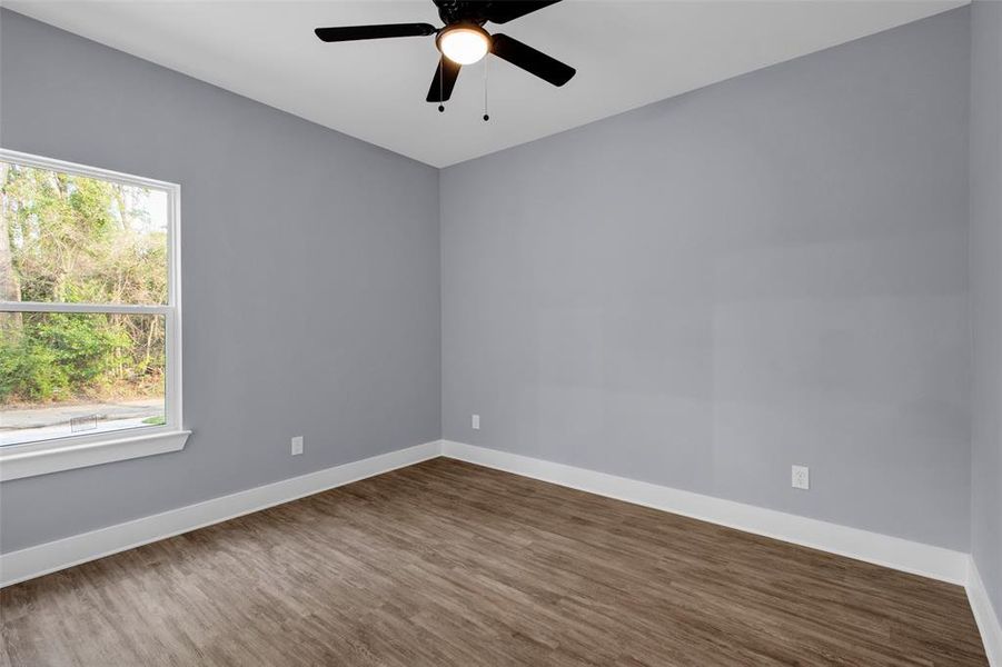 Unfurnished room with wood finished floors and ceiling fan