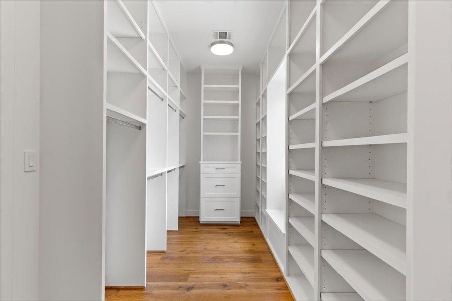 Opposite side of the primary closet has more built-ins and a window bench seat