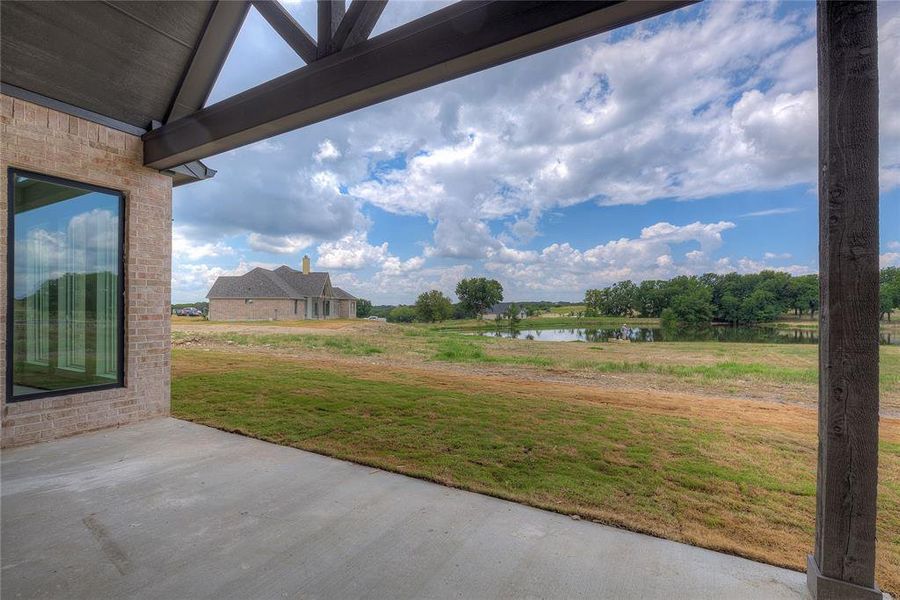 View of yard with a patio and a water view