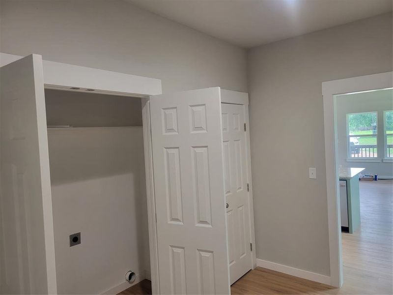Utility closet featuring a dryer vent and washer hookups