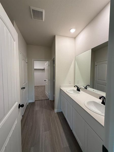 Bathroom featuring wood finished floors, double vanity, a textured ceiling, and recessed lighting Bathroom featuring wood finished floors, double vanity, a textured ceiling, and recessed lighting