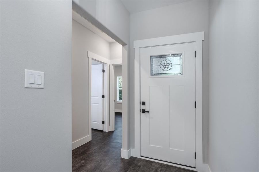 Foyer entrance featuring baseboards and dark wood-style floors Foyer entrance featuring baseboards and dark wood-style floors