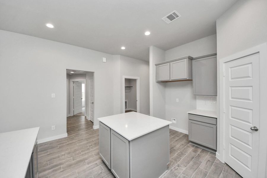 Discover another perspective of this stunning kitchen, generously appointed with an abundance of counter space. Sample photo of completed home with similar floor plan. Actual colors and selections may vary. Discover another perspective of this stunning kitchen, generously appointed with an abundance of counter space. Sample photo of completed home with similar floor plan. Actual colors and selections may vary.