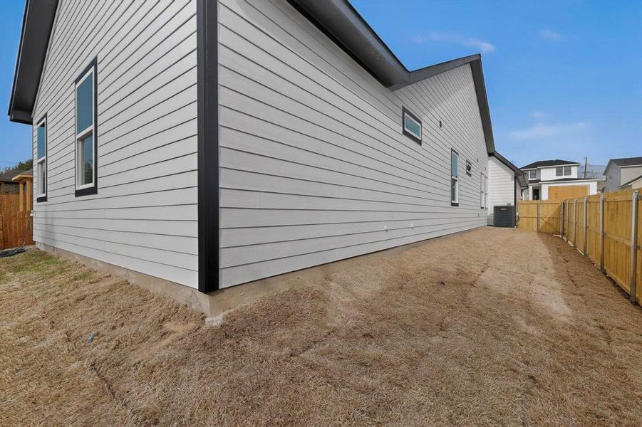 View of side of home featuring a fenced backyard and a cooling unit View of side of home featuring a fenced backyard and a cooling unit