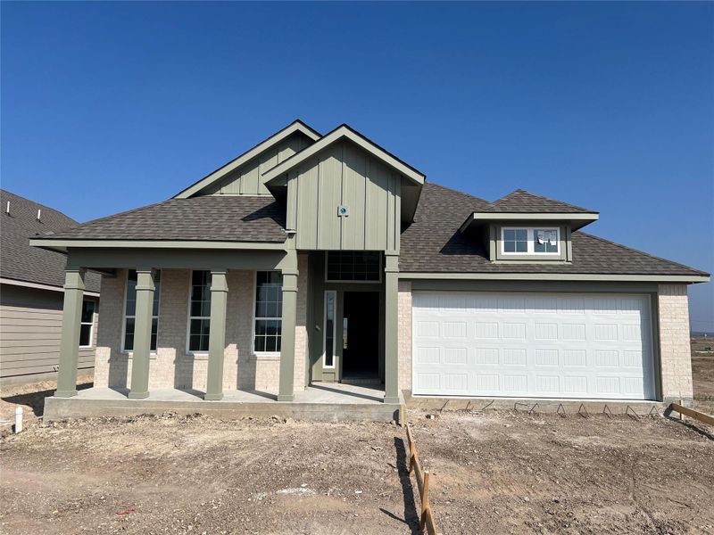 View of front of house with roof with shingles, driveway, board and batten siding, and brick siding