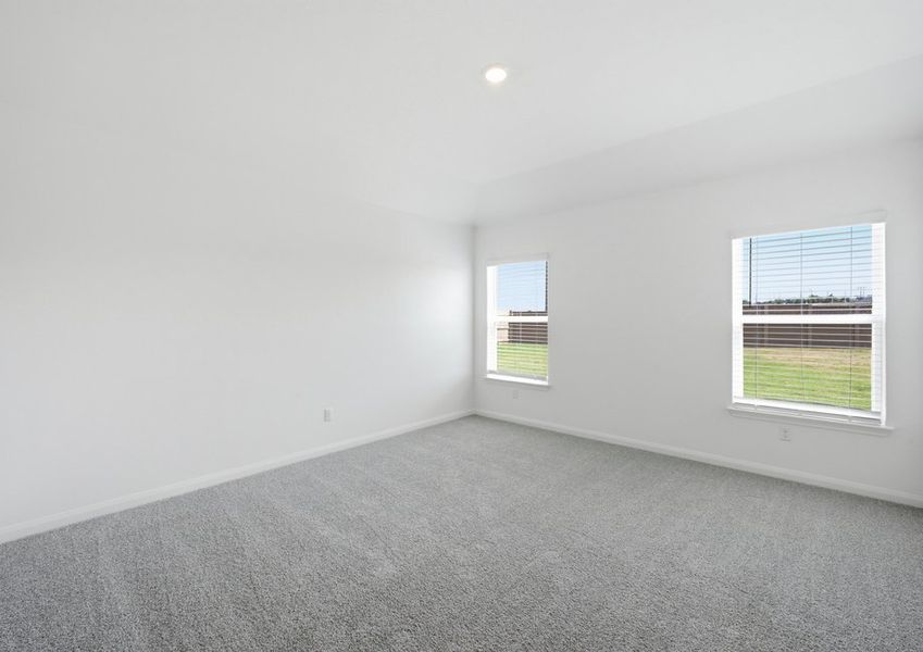 Spacious carpeted primary bedroom featuring windows with natural light. Spacious carpeted primary bedroom featuring windows with natural light.