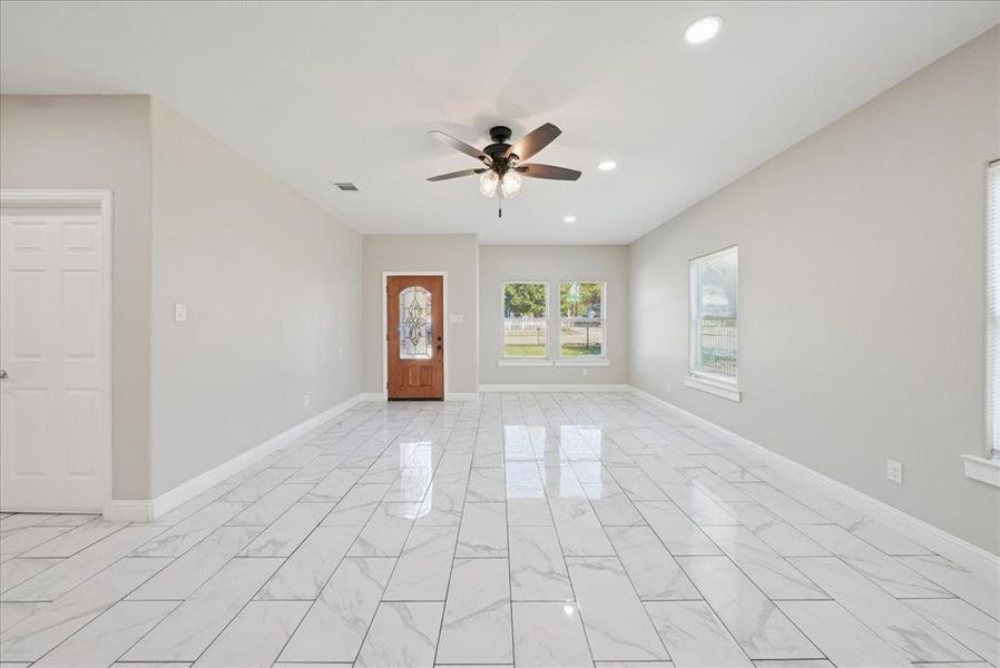 Unfurnished room featuring light marble finish floors, recessed lighting, and a ceiling fan