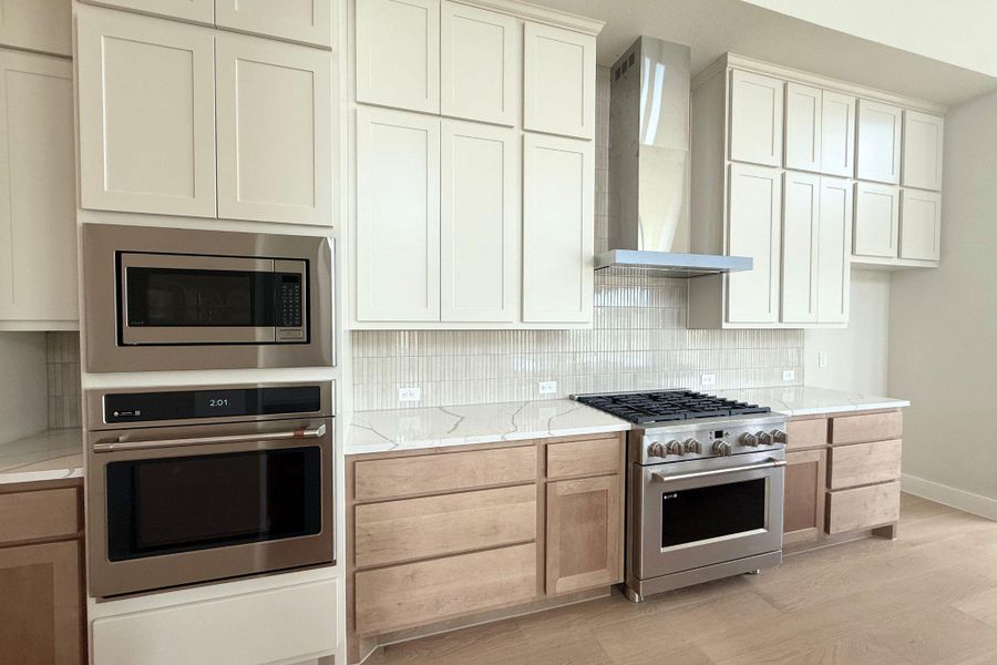 A contemporary kitchen features sleek cabinetry, a gas range, and double ovens for culinary excellence. A contemporary kitchen features sleek cabinetry, a gas range, and double ovens for culinary excellence.