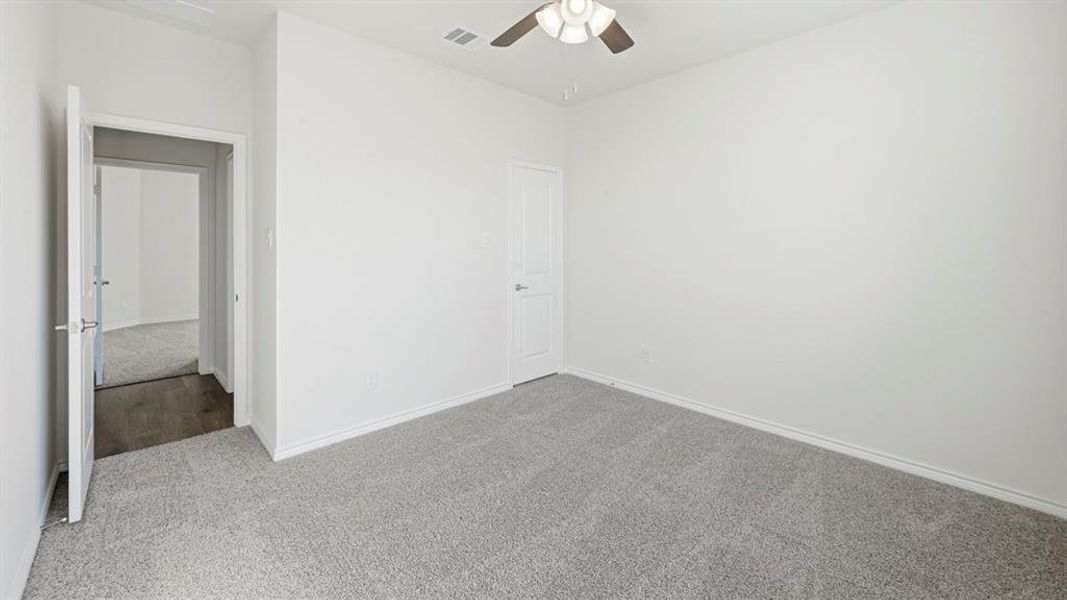 Unfurnished bedroom featuring carpet flooring and ceiling fan