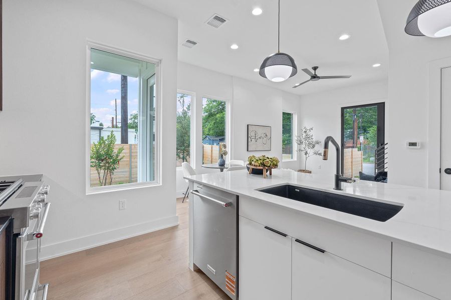 Kitchen with appliances with stainless steel finishes, recessed lighting, light wood finished floors, light countertops, and a ceiling fan