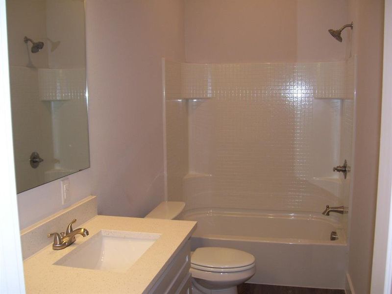 Primary bathroom with vanity, tub / shower combination, and toilet