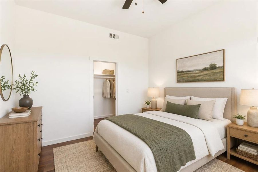 Spacious room featuring wood-finish flooring, a ceiling fan, and a built-in closet with shelving and hanging rod