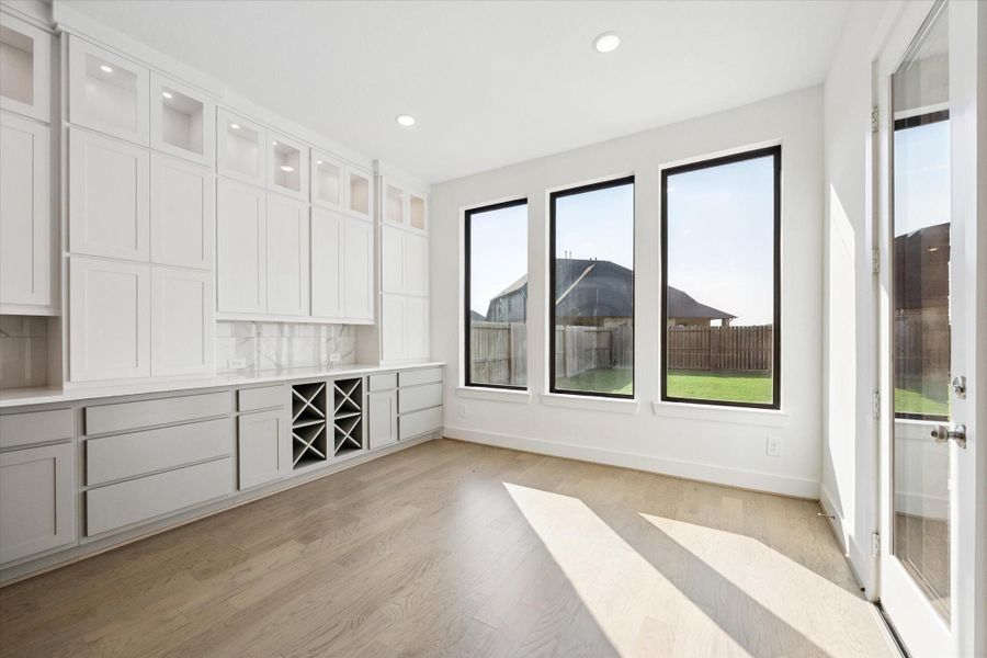 The informal dining area features a wall of windows, a wall of built in cabinets that features several pots and pan drawers and extends throughout the entire length of the kitchen. The informal dining area features a wall of windows, a wall of built in cabinets that features several pots and pan drawers and extends throughout the entire length of the kitchen.