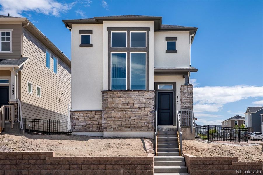 Front exterior of a new home in Revel Crossing at Wolf Ranch – The Ascent Collection, Colorado Springs, CO, highlighting curb appeal (Image 23).